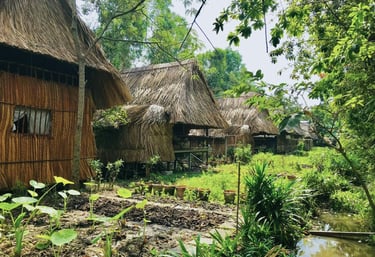 Traditional thatched-roof cottages surrounded by lush gardens at Saigon Garden Homestay.