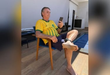 a man sitting in a chair with his feet up and holding a cell phone