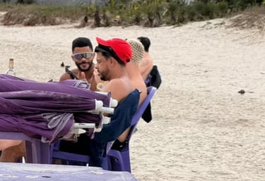 a man in a red hat and sunglasses on a beach