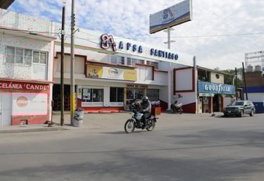 a motorcycle rider riding down a street in front of a building