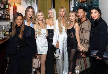 Fashion insiders posing together at a stylish New York Fashion Week event.