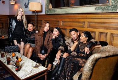Guests in chic black and brown outfits at a New York Fashion Week party.