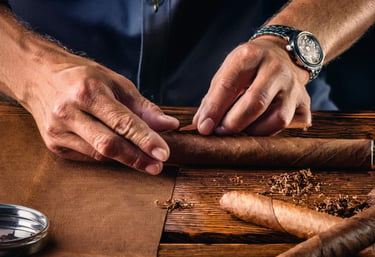 Image of a cigar roller's hands as he works on a cigar.
