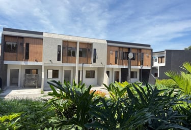 Modern, serene townhomes in Pandi, Bulacan, featuring warm wood accents and lush tropical greenery.