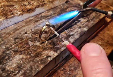 a person holding a small piece of metal with a blue flame