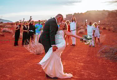 a bride and groom kissing in the desert