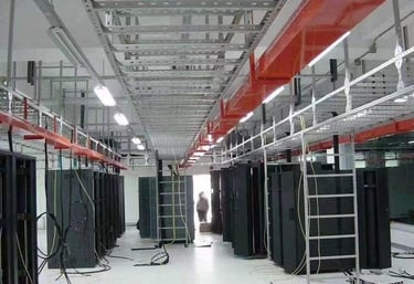 una sala grande con muchos equipos informáticos y escalera de cables y bandeja de cables