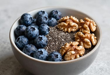A vibrant bowl of superfoods including blueberries, chia seeds, and walnuts on a light grey stone surface.
