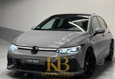 Grey Volkswagen Golf GTI rental car with black wheels parked in a Marbella showroom.
