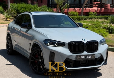 Luxury grey BMW X4 M Competition rental car parked in Marbella on a sunny day.