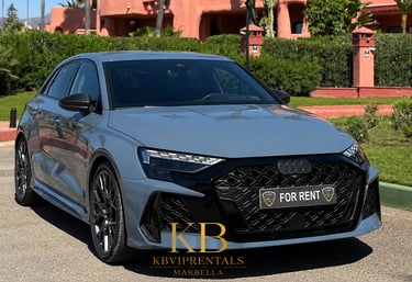 Luxury Audi RS3 sportback car rental in Marbella parked in front of a Mediterranean villa.