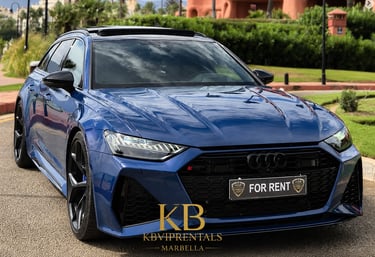 Luxury blue Audi RS6 Avant rental car parked on a sunny street in Marbella.
