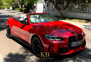 Red BMW M4 convertible luxury car for rent parked on a sunny street in Marbella.