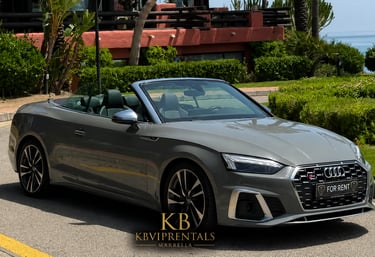 Grey Audi S5 convertible luxury car rental parked on a sunny street in Marbella.