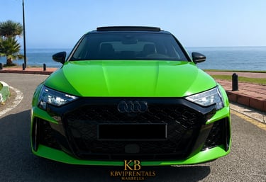 Front view of a lime green Audi RS3 luxury rental car parked by the sea in Marbella.
