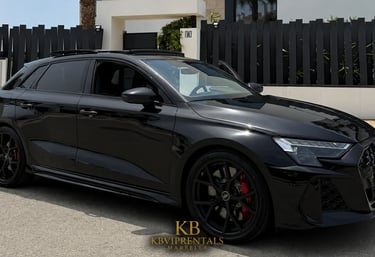 Sleek black Audi RS3 Sportback with red brake calipers parked outside a luxury villa in Marbella.