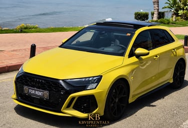 Yellow Audi RS3 luxury car rental parked by the ocean in Marbella with panoramic sunroof open.