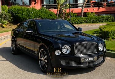 Luxury black Bentley Mulsanne sedan for rent parked at a high-end resort in Marbella.