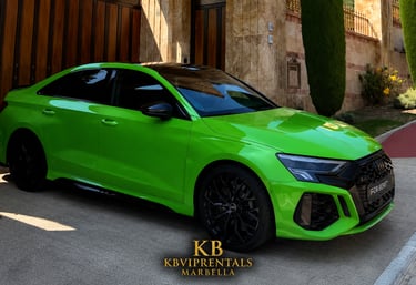 A bright Kyalami Green Audi RS3 luxury sedan parked in front of a stone villa for rent in Marbella.