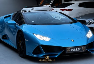 A bright blue Lamborghini Huracan Evo Spyder luxury car rental parked in a showroom garage.