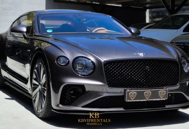 Luxury dark grey Bentley Continental GT rental car parked in Marbella.