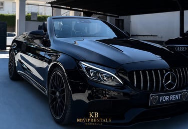A sleek black Mercedes-Benz AMG convertible luxury car rental parked in Marbella.