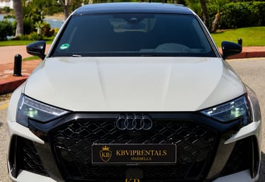 Front view of a white Audi RS3 luxury rental car parked in Marbella with a black honeycomb grille.