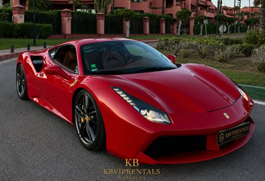 A red Ferrari 488 GTB luxury sports car parked on a road in Marbella, Spain.