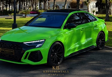 A bright green Audi RS3 luxury sedan parked in a sunny garden setting for KB VIP Rentals in Marbella.