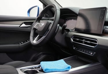 A technician carefully restoring a car’s carpet inside a sleek vehicle.