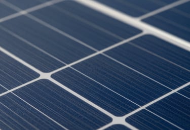 Close-up macro photography of high-efficiency solar cells showing the silicon texture and grid lines. The lighting highlights the deep navy blue color of the monocrystalline cells, suggesting premium quality and innovation.