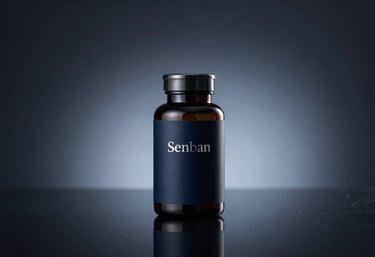 Studio shot of a minimalist dark navy supplement bottle with elegant silver typography. The bottle is placed on a reflective dark surface with a subtle light blue glow from the side. Premium and clinical aesthetic.