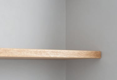 A close-up of a perfectly finished carpentry joint or a neatly installed shelf. The focus is sharp, the wood is clean, and the surrounding walls are a crisp grey #F5F8FA. The composition is modern and minimalist.