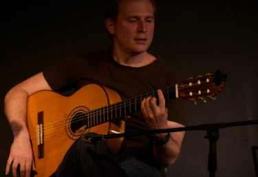 a man playing a guitar in a dark room