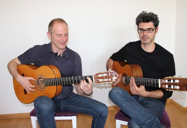 master and student men playing flamenco guitar together