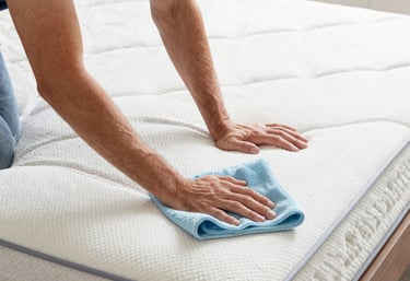 A professional cleaner carefully wiping a kitchen countertop in a bright, modern home.