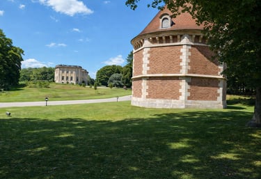 Historic French chateau and brick tower at Petit Trianon estate in Versailles park.