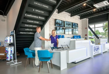 A customer shaking hands with a staff member at a modern POM Self-Storage reception desk office.
