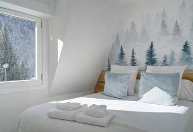 diseñadora de interiores en Val d’Aran dormitorio con mural natural y diseño acogedor
