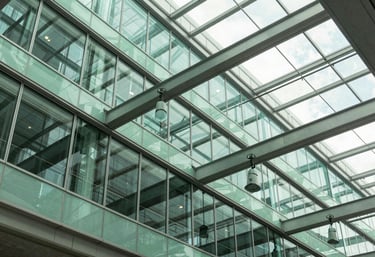 An abstract photography shot of a modern glass and steel architectural ceiling in a US tech office, with Mint Green reflections and sophisticated lighting.