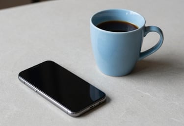 A clean, minimalist workspace with a light blue coffee mug and a sleek smartphone on a light gray surface. Aesthetic is user-centric. Global / Tech-focused.
