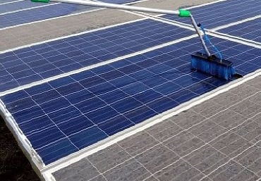 a person cleaning a solar paneled roof