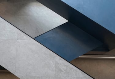 An abstract photograph of a modern staircase inside a financial institution in North America. The composition uses geometric shapes in light grey and steel blue to suggest progress and sophisticated design.