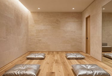 Minimalist interior of La Shala Nord yoga studio in Valencia featuring light oak wood floors, low warm silver floor cushions, pale stone walls, soft indirect lighting, quiet boutique hotel retreat aesthetic.