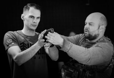 vyras su ginklu rankose ir instruktorius šalia