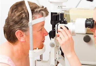 Mulher realizando exame oftalmológico com lâmpada de fenda, utilizado para diagnóstico de catarata e