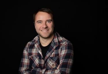 un homme souriant en chemise à carreaux