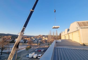 grúa de AISPAM subiendo equipos a una azotea 