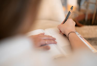 Frau schreibt Notizen ihres Stressmanagement-& Burnout Prävention Beratungsgesprächs in ein Buch