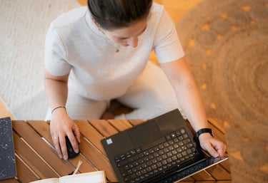Eine Frau im Schneidersitz auf dem Boden sitzend, arbeitet an ihren Stressmanagement Beratungsangebo